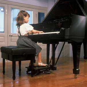 kid with piano pedal extender